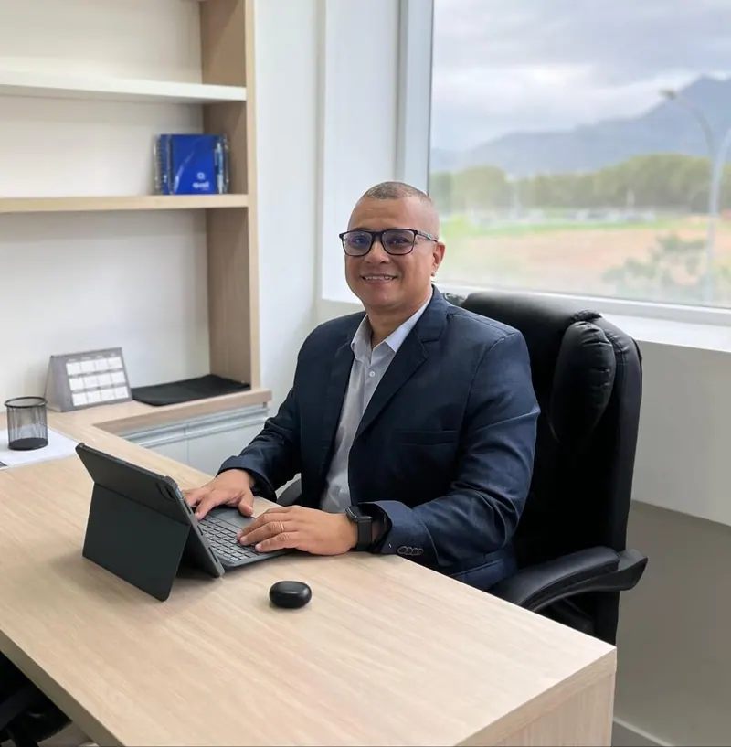 Anderson Muquem no escritório, à mesa com o notebook